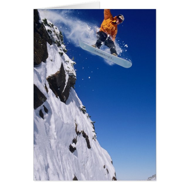 Man on a snowboard jumping off a cornice at (Front)