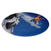 Man on a snowboard jumping off a cornice at
