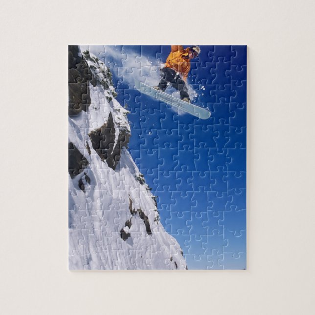 Man on a snowboard jumping off a cornice at jigsaw puzzle (Vertical)