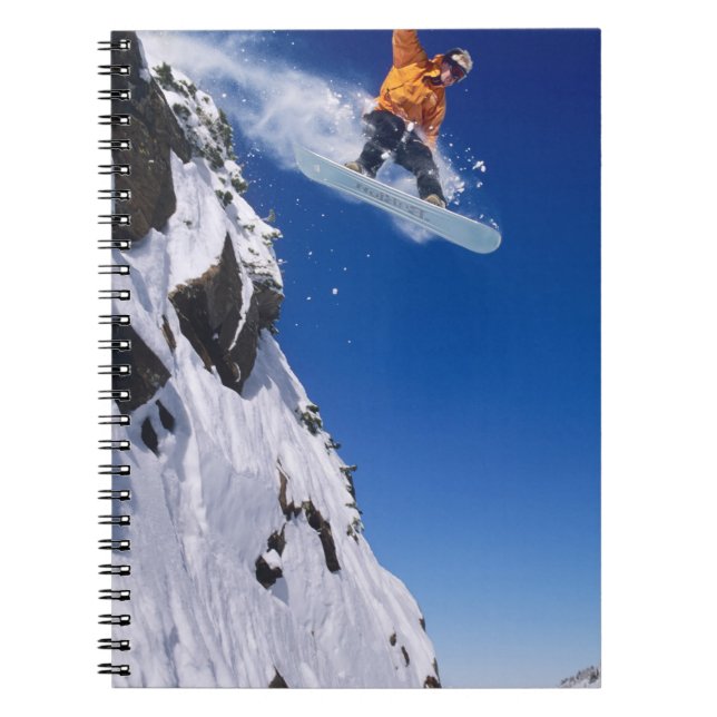 Man on a snowboard jumping off a cornice at notebook (Front)