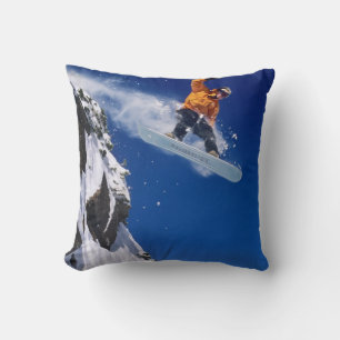 Man on a snowboard jumping off a cornice at throw pillow