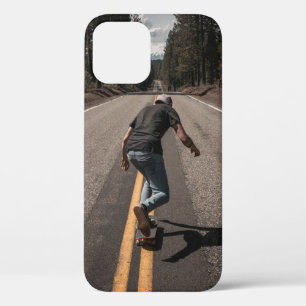 Man playing skateboard on road in the morning iPhone 12 case