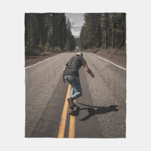 Man playing skateboard on road in the morning fleece blanket
