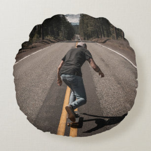 Man playing skateboard on road in the morning round pillow
