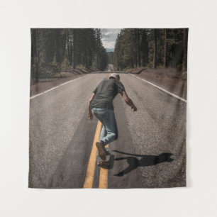 Man playing skateboard on road in the morning tapestry