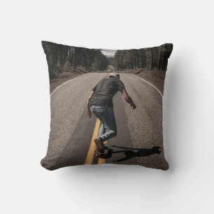 Man playing skateboard on road in the morning throw pillow
