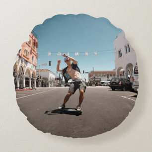 Man playing skateboard round pillow