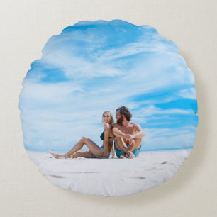 Man sitting beside of woman in black bikini top round pillow