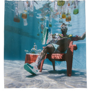 Man sitting on chair underwater with floating bott
