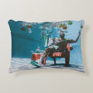 Man sitting on chair underwater with floating bott accent pillow