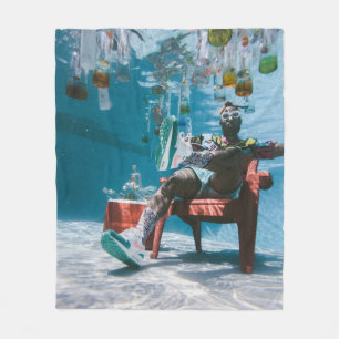 Man sitting on chair underwater with floating bott fleece blanket