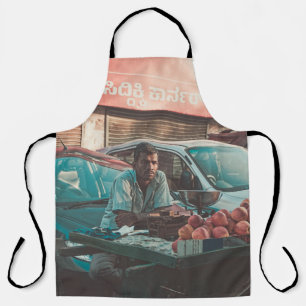 MAN VENDING APPLES NEAR PARKED CARS APRON