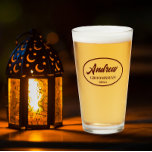 Maroon Stylized Wedding Groomsman Name Glass<br><div class="desc">Beer glass for the wedding groomsman that features his name printed in dark maroon, stylized script inside a maroon colour oval border along with wedding date. A great party supply idea for a bachelor party! Personalize your beer glass by editing and replacing name and date with your own. Available in...</div>