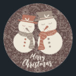 Mellow Snowmen - Merry Christmas 2 snowman red.  Classic Round Sticker<br><div class="desc">Two cute mellow smiling snowman in neutral earth tone terra cotta amaro red hats and scarfs set on a warm fall chocolate brown background with line drawn flowers and holly. The Merry Christmas text is fully editable and you can add your own text. There is also a version of this...</div>