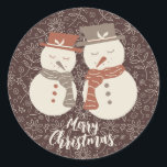 Mellow Snowmen - Merry Christmas 2 snowman red. Classic Round Sticker<br><div class="desc">Two cute mellow smiling snowman in neutral earth tone terra cotta amaro red hats and scarfs set on a warm fall chocolate brown background with line drawn flowers and holly. The Merry Christmas text is fully editable and you can add your own text. There is also a version of this...</div>