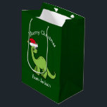 Merry Christmas Dinosaur in Santa Hat Custom Kids Medium Gift Bag<br><div class="desc">Cute holiday animals are my favourite part of Christmas. A cool green dinosaur wearing a red Santa hat and looking happy. This personalized kids gift bag fills me with the Christmas spirit.</div>