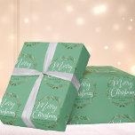 Merry Christmas Pretty Light Green Wreath Custom Wrapping Paper<br><div class="desc">Beautiful white cursive script reading Merry Christmas is scrawled over an elegant holly wreath with pretty green mistletoe. The lovely calligraphy overlaps the holiday vines above your custom text. Perfect personalized holiday gift wrap for a family with their name and year. Lovely light green custom wrapping paper.</div>