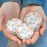 Midsummer Floral Bridesmaid 2 Inch Round Button<br><div class="desc">Identify the key players at your bridal shower with our elegant,  sweetly chic floral buttons. Button features a watercolor floral wreath of peachy pink peonies,  white hydrangea flowers and botanical greenery with "bridesmaid" inscribed inside in hand lettered script.</div>