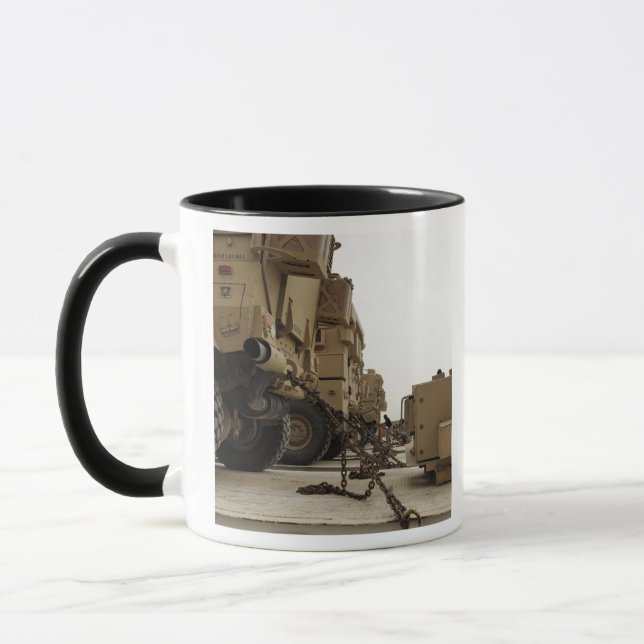 Military vehicles are locked down on semi truck mug (Left)