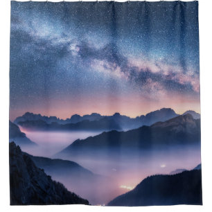 Milky Way over mountains in fog at night in summer