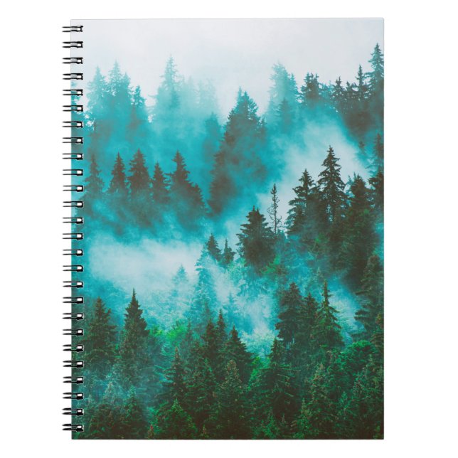Misty foggy mountain landscape with fir forest and notebook (Front)