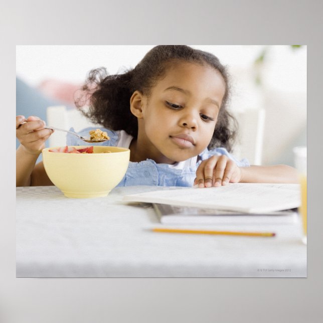 Mixed race girl reading and eating breakfast poster (Front)