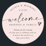 Modern Blush Pink Wedding Welcome Hotel Bag Classic Round Sticker<br><div class="desc">Modern Blush Pink Wedding Welcome Hotel Bag Classic Round Sticker Blush Pink Hotel Bag Stickers: Greet loved ones in style with these blush pink modern handwriting hotel bag stickers, designed for a romantic yet minimalist look. The 3-inch round design reads “welcome friends & family” with a heart accent and room...</div>