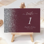 Modern Burgundy Silver Glitter Edge Wedding Table Number<br><div class="desc">The left-hand edge of this elegant modern wedding table number features a silver faux glitter design. The customizable text combines silver grey handwriting,  copperplate and italic fonts on a burgundy background.</div>