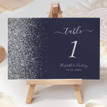 Modern Dark Blue Silver Glitter Edge Wedding Table Number<br><div class="desc">The left-hand edge of this elegant modern wedding table number features a silver faux glitter design. The customizable text combines silver gray handwriting,  copperplate and italic fonts on a dark navy blue background.</div>