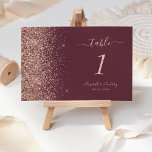 Modern Dark Burgundy Rose Gold Glitter Wedding Table Number<br><div class="desc">The left-hand edge of this elegant modern wedding table number features a rose gold faux glitter design. The customizable text combines pale rose-coloured handwriting,  copperplate and italic fonts on a dark burgundy background.</div>