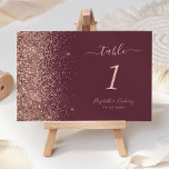 Modern Dark Burgundy Rose Gold Glitter Wedding Table Number<br><div class="desc">The left-hand edge of this elegant modern wedding table number features a rose gold faux glitter design. The customizable text combines pale rose-coloured handwriting,  copperplate and italic fonts on a dark burgundy background.</div>