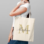 Modern Elegant Gold Black Personalized Monogram Tote Bag<br><div class="desc">Modern and elegant tote bag features a simple and minimal custom gold and black (colours can be modified) personalized monogram design that can be personalized with an initial and name in script. Perfect gift for your wedding party - maid of honour, bridesmaids, mothers of the bride and groom, and flower...</div>