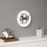 Modern Elegant Monogram Name Black Gold Script Round Clock<br><div class="desc">The Modern Elegant Monogram Name Black Gold Script Clock is a stylish and personalized timepiece perfect for any home or office setting. This clock features a sleek black face with elegant gold script, allowing you to customize it with your monogram and name. The modern design and sophisticated colour scheme make...</div>