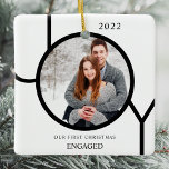 Modern First Christmas Engaged Photo Ceramic Ornam Ceramic Ornament<br><div class="desc">This modern First Christmas Engaged Photo Ornament is decorated with the word JOY in black on a white background.
Easily customizable with your photo and name.</div>