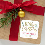 Modern Gold Script Merry Christmas Custom Square Sticker<br><div class="desc">Stylish Merry Christmas holiday favour sticker features antique gold script writing and accents of green branches with holly leaves and red berries. Personalize with custom name / family and year text. The white background colour can be modified.</div>