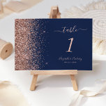 Modern Navy Blue Rose Gold Glitter Wedding Table Number<br><div class="desc">The left-hand edge of this elegant modern wedding table number features a rose gold faux glitter design. The customizable text combines rose pink handwriting,  copperplate and italic fonts on a navy blue background.</div>