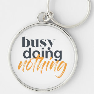 Modern, trendy, urban design of Busy Doing Nothing Keychain