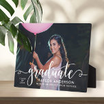 Modern White Script Graduate Photo Graduation Plaque<br><div class="desc">Stylish and elegant graduation plaque sign with easel features a senior photo with "graduate" white script overlay. Personalize the modern custom text with your grad's name,  school,  and class year. Makes a beautiful keepsake to display in your home!</div>