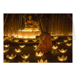 Monks lighting khom loy candles and lanterns for