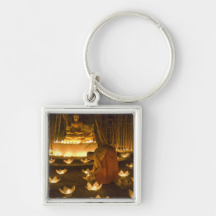 Monks lighting khom loy candles and lanterns for keychain
