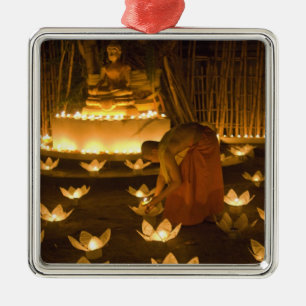 Monks lighting khom loy candles and lanterns for metal ornament
