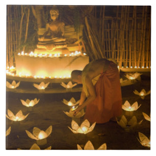 Monks lighting khom loy candles and lanterns for tile