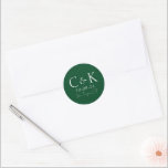 Monogram Initials on Forest Green Wedding Classic Round Sticker<br><div class="desc">These custom wedding sticker labels feature a simple and modern design. Two sample monogram initials are pictured in the centre,  followed by a wedding date and location. The background features an elegant and earthy forest green colour.</div>
