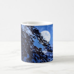 Moon over snowy fir tree and sea coast at night coffee mug
