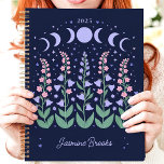 Moonlit Moon Phase Garden 2025 Custom Name Planner<br><div class="desc">Escape to a moonlit garden where dreams bloom under the celestial glow. This enchanting planner, adorned with moon phases and blossoming flowers, invites you to plan your year under the stars. Imagine yourself jotting down your aspirations and appointments amidst this tranquil nocturnal scene. Personalize it with your name and let...</div>