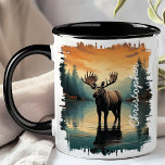 Moose at Sunrise Lake Reflection Mug<br><div class="desc">Begin your day with the majestic beauty of the Moose at Sunrise Lake Reflection Mug. This captivating mug features a stunning image of a moose standing in a serene lake at sunrise, with the warm colours of dawn and the tranquil forest beautifully reflected in the water. Customized with your name,...</div>