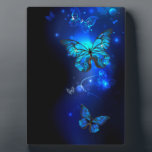 Morpho Butterfly in the Dark Background Plaque<br><div class="desc">blue,  glowing butterflies morpho on a dark background. Morpho. Design with butterflies.</div>