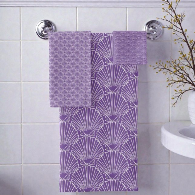 Motif Shell de la mer Blanche sur Purple Beach Hou (Seashell pattern bathroom towel set hanging on a rack on a bathroom wall.)