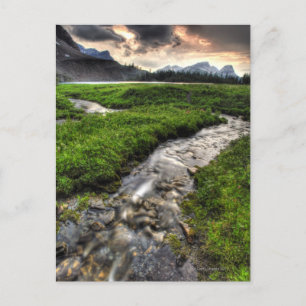 Mountain creek descends through meadow toward postcard