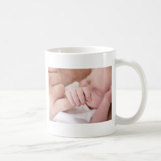 Mug bébé nouveau-né tenant le doigt de pères